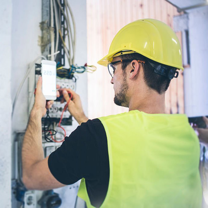 An electrician fixing up the wires and measuring volts